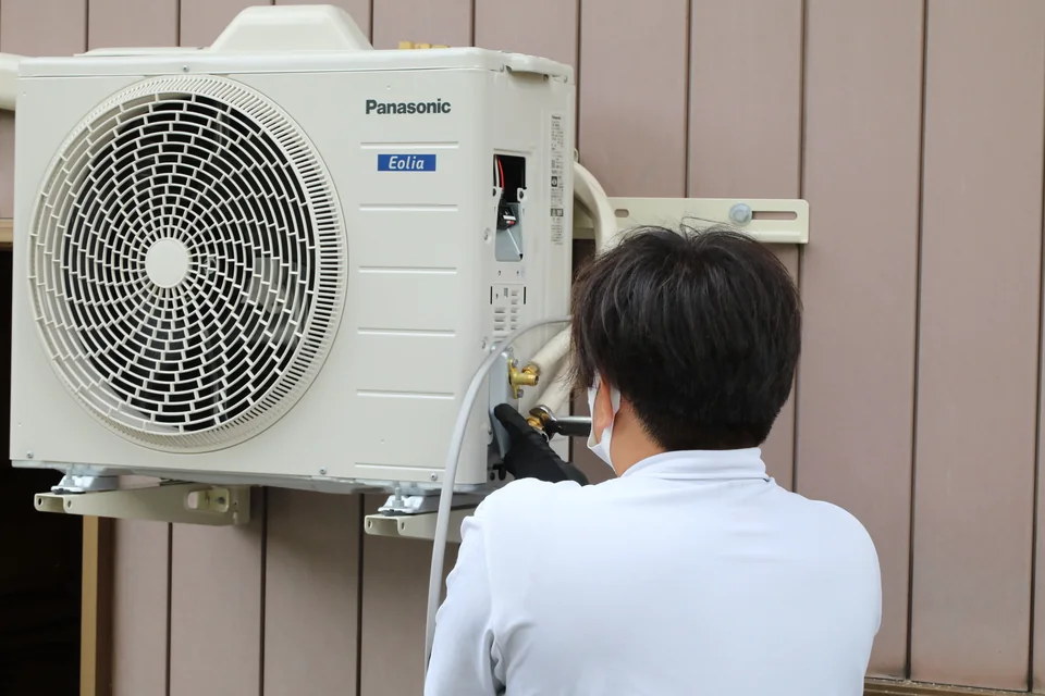 Panasonic製エアコン室外機の配管を接続する技術者